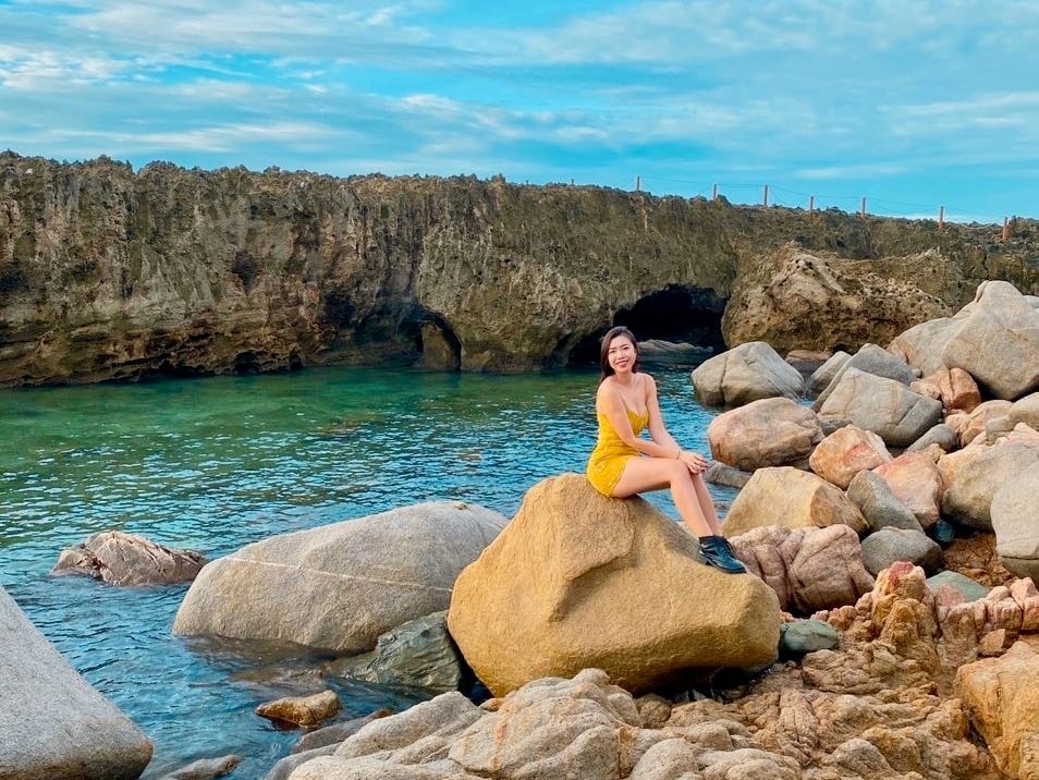 Woman Sitting In Front Of Hang Rai Fossilized Coral in Hang Rai, Vietnam