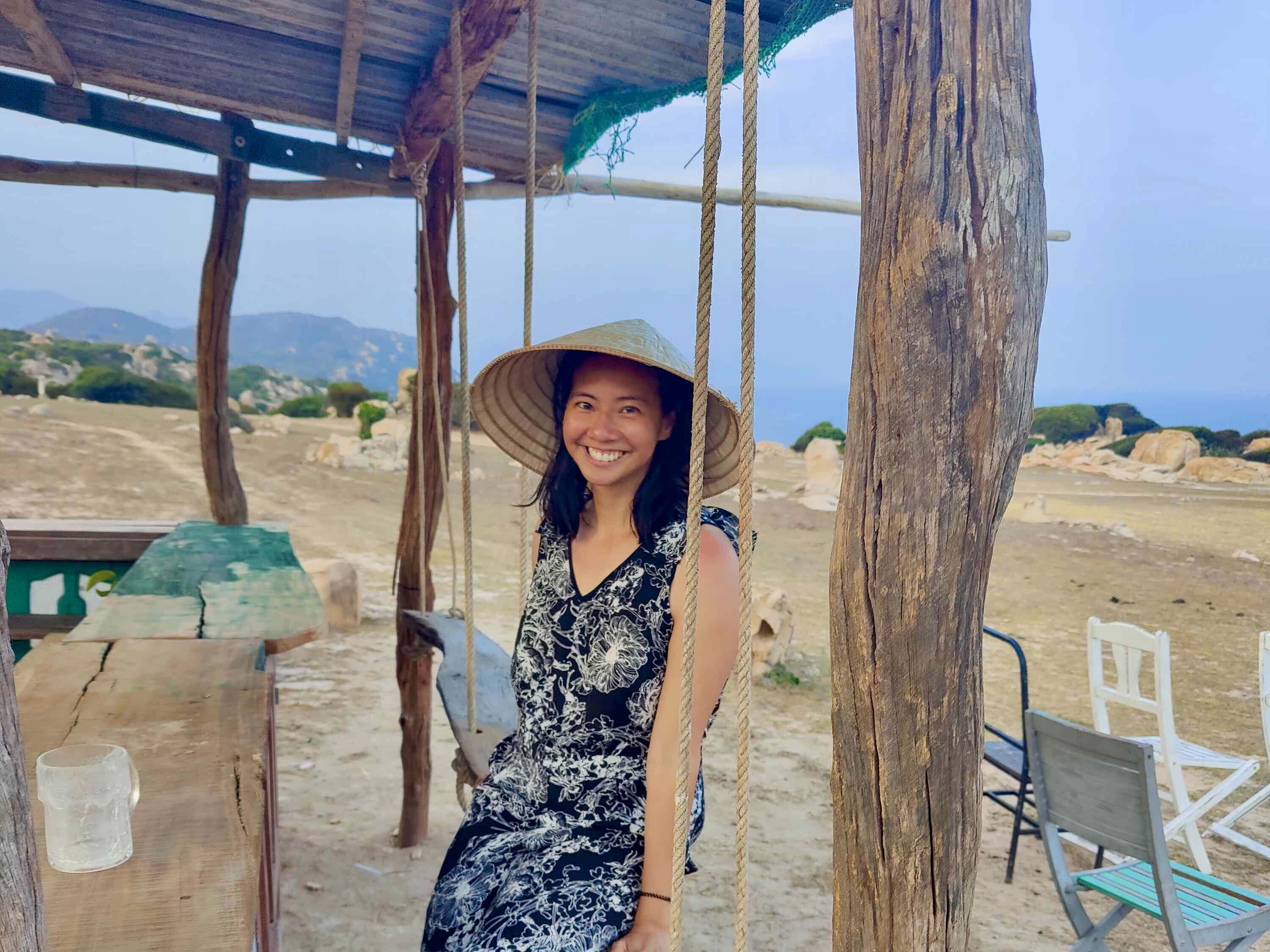 Beautiful Woman In Vietnamese Hat Sitting At Colorful Bar, Rua Da Cafe, At Stone Park (Cong Vien Da)