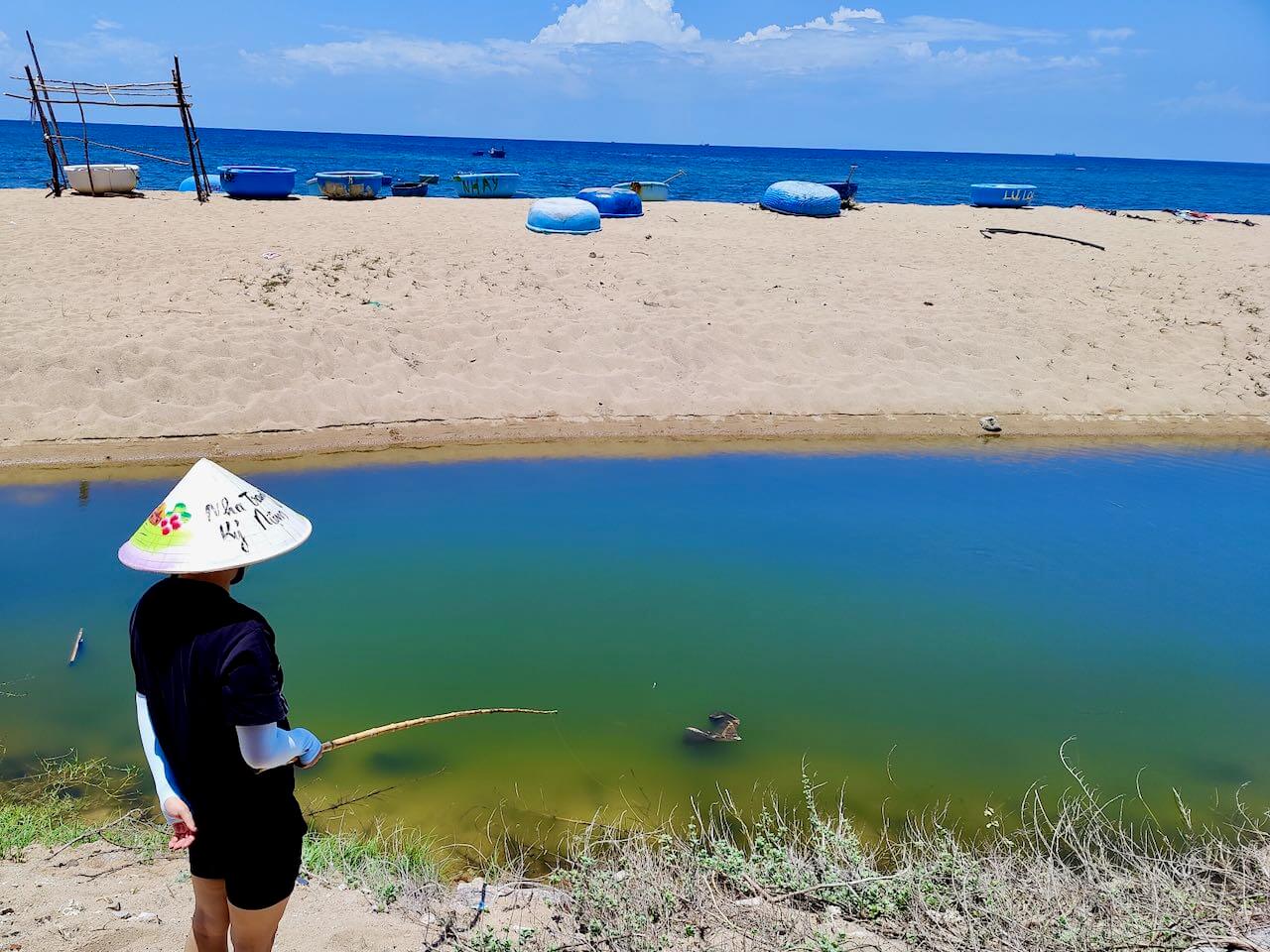 Woman Fishing In Fresh Water Pond With View Of Beach of Hang Rai, Vietnam